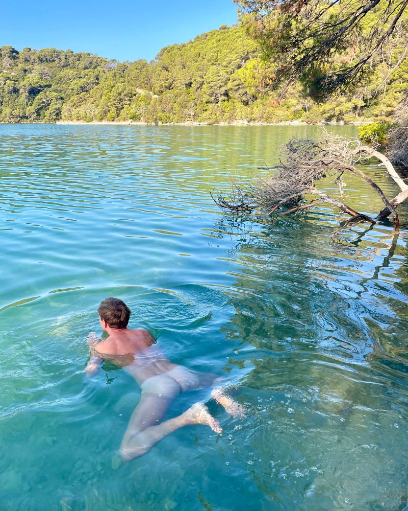 naked guy swimming in a lake