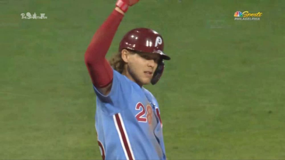 a baseball player wearing a blue jersey with the number 28 on the front