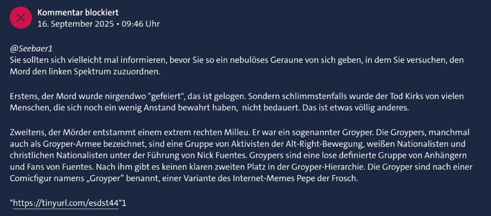 Das Bild zeigt einen Screenshot eines blockierten Kommentars auf einer Nachrichtenseite, vermutlich „Tagesschau“. Links oben ist ein großer roter Kreis mit weißem X, das anzeigt, dass der Kommentar gesperrt wurde. Daneben ist fett und weiß „Kommentar blockiert“ sowie das Datum „16. September 2025, 09:46 Uhr“ zu sehen.

Darunter folgt in weißer Schrift auf dunkelblauem Hintergrund der Text des Kommentars. Der Kommentar spricht eine andere Nutzerin direkt an (@Seebaer1) und fordert dazu auf, sich besser zu informieren. Es wird argumentiert, dass der Mord an Kirk nicht gefeiert wurde, sondern sein Tod höchstens nicht bedauert wurde, was etwas anderes sei. Im Hauptteil beschreibt der Kommentator, dass der Mörder aus einem extrem rechten Milieu komme und Mitglied der sogenannten „Groyper“-Bewegung sei. Die Groyper werden als Aktivisten der Alt-Right, weiße Nationalisten und christliche Nationalisten unter Führung von Nick Fuentes beschrieben. Weiter wird erklärt, dass die Groyper nach einer Comicfigur namens „Groyper“ benannt sind – eine Variante des Internet-Memes „Pepe der Frosch“.

Am Ende steht ein Link als Text: „https://tinyurl.com/esdst44“.

