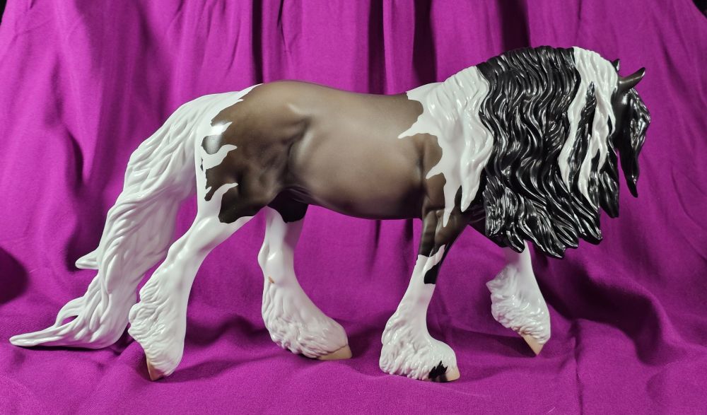 A photo of the right side of Stone model horse Cthulhu, on the Irish cob mold. He is a grulla tobiano; the white on his shoulders looks like wings while is neck, legs, and haunches appear to have tentacles.