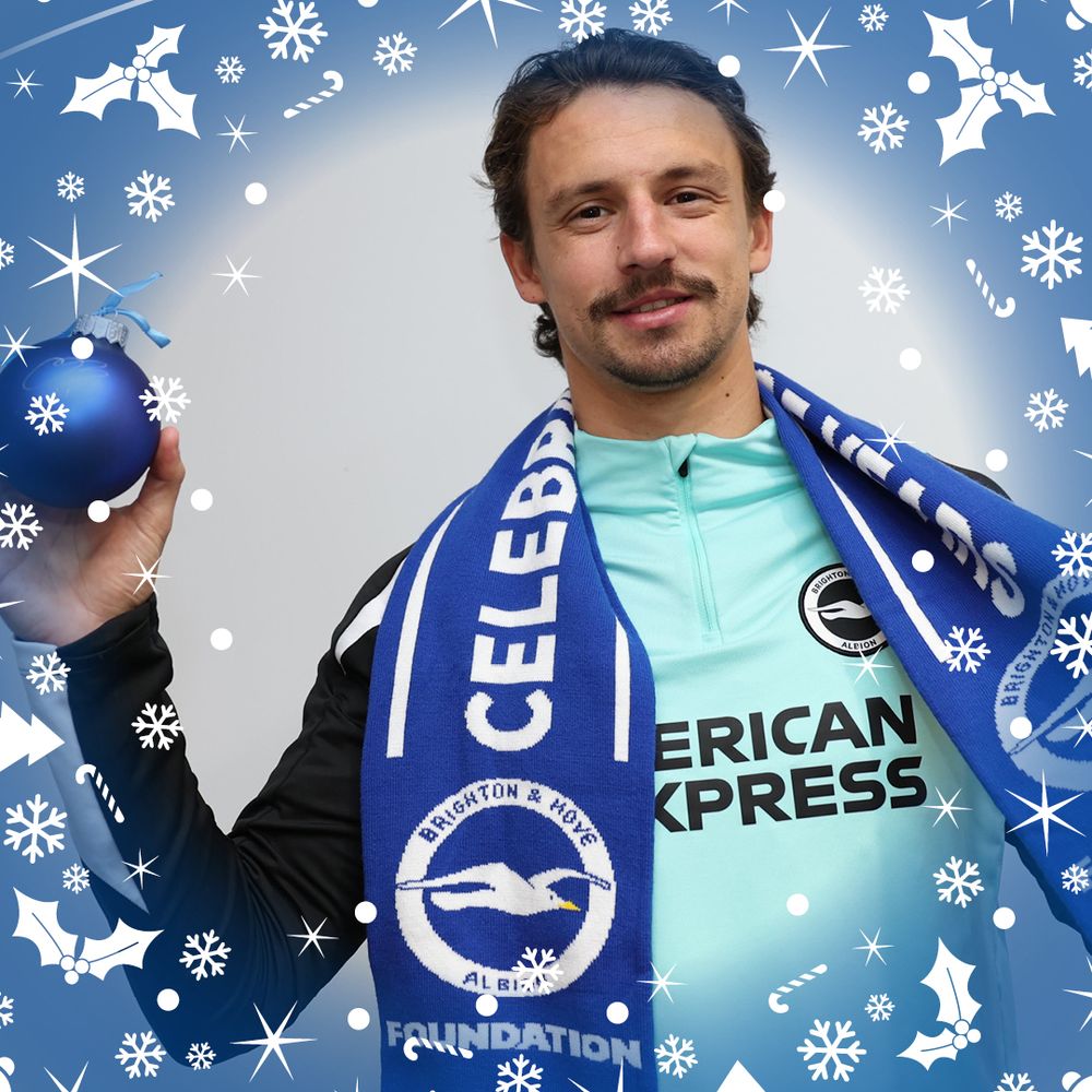 Olivier Boscagli holds a Foundation scarf with one hand and his unique signed bauble with the other