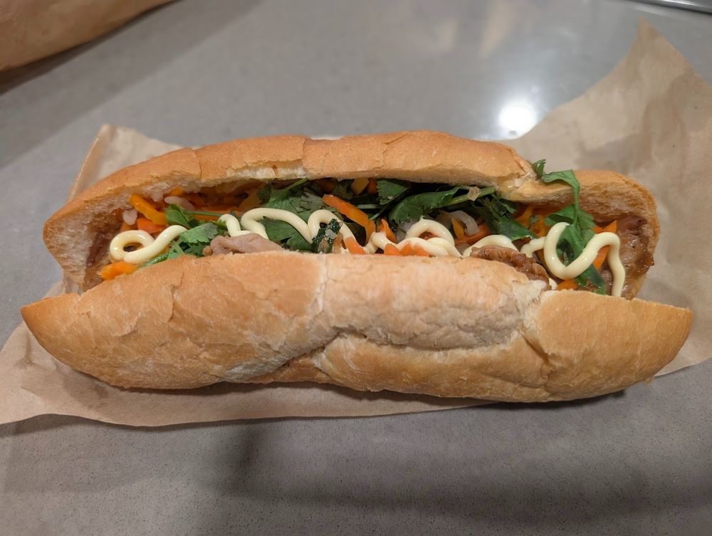 A vietnamese bánh mì sandwich. It's a 10 inch long white bread roll stuffed with meat, vegetables, butter, and mayo.