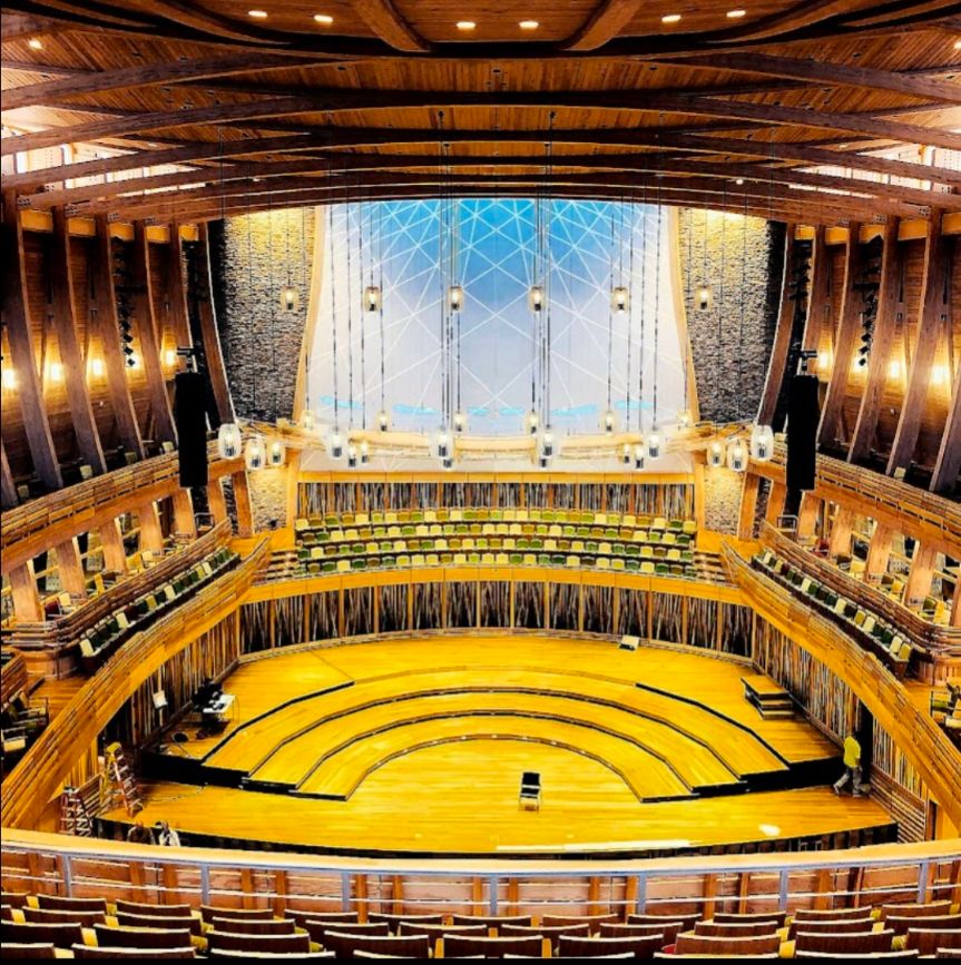 Interior of Groton Hill Music Center Concert Hall showing the stage surrounded by 360° seating, two balconies and elegant timber roof