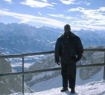 Poet on top of Mount Pilatus, Lucerne, Switzerland with snow covered Switz Alps in the background.  