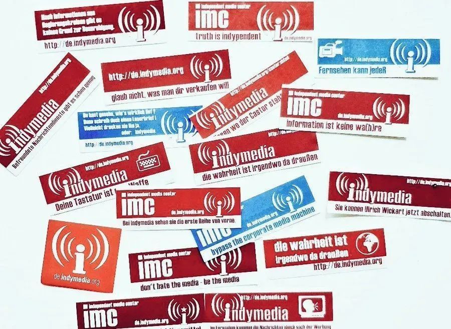 Durcheinandergewürfelte Sammlung verschiedener indymedia Sticker/Logos aus diversen Ländern. 