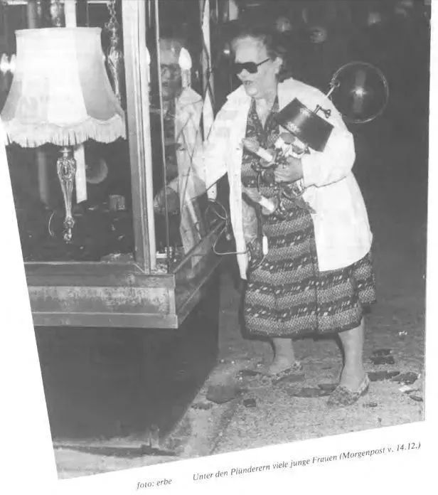 Zeitungsfoto einer älteren Dame sie sich aus einer eingeschlagenen Vitrine am Kudamm bedient. Unterschrift: "Unter den Plünderern viele junge Frauen"