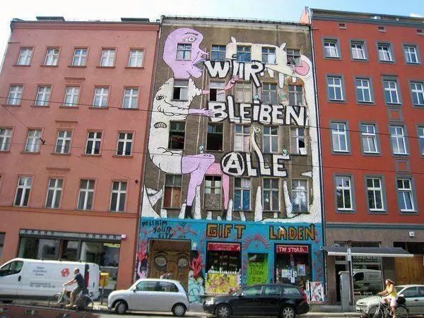 Fassadenfoto vom Haus vor der Röumung mit großem "Wir bleiben Alle" Wandbild.