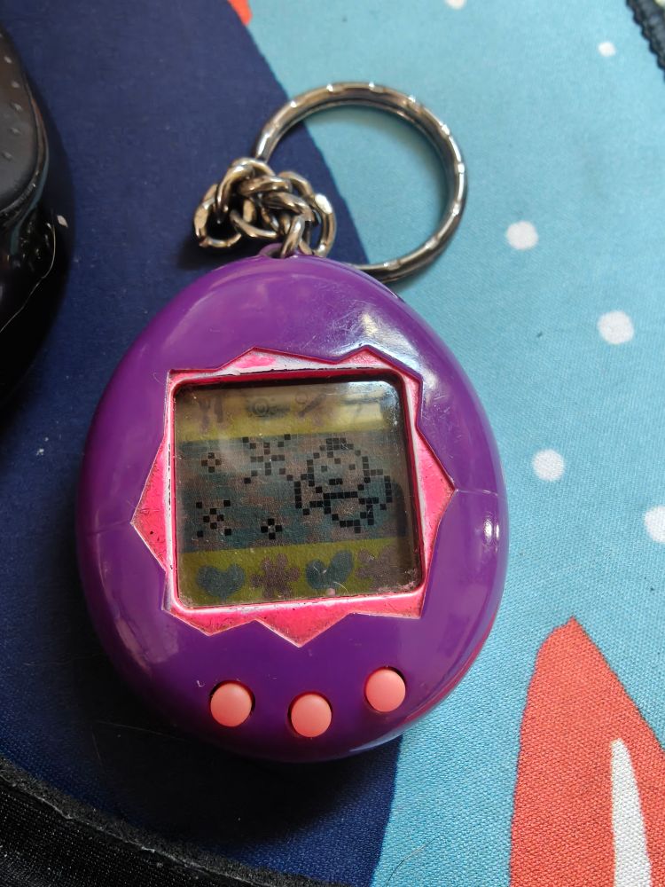 Photo of my tamagotchi with a little angel on it signifying that my tamagotchi has died or "has gone to his home planet" depending on your interpretation of the lore