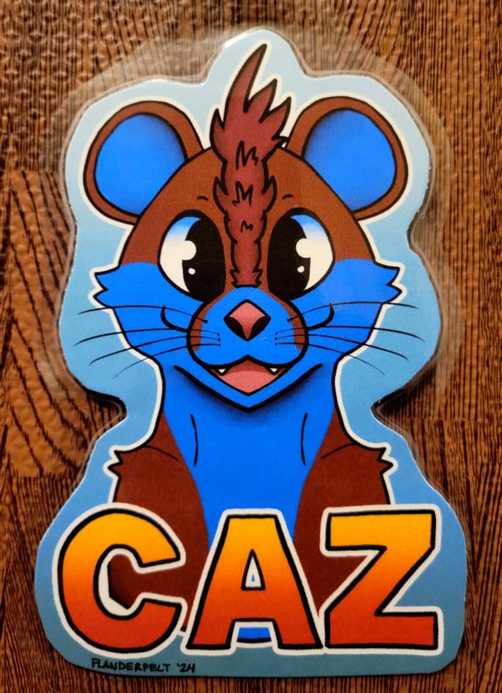 Symmetrical badge example ($30 digital, $50 physical) of Caz, a brown/blue-colored otter with a reddish-brown mohawk and black eyes