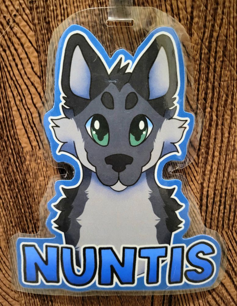 Symmetrical badge of Nuntis, a gray/cream-colored wolf with vibrant, green eyes