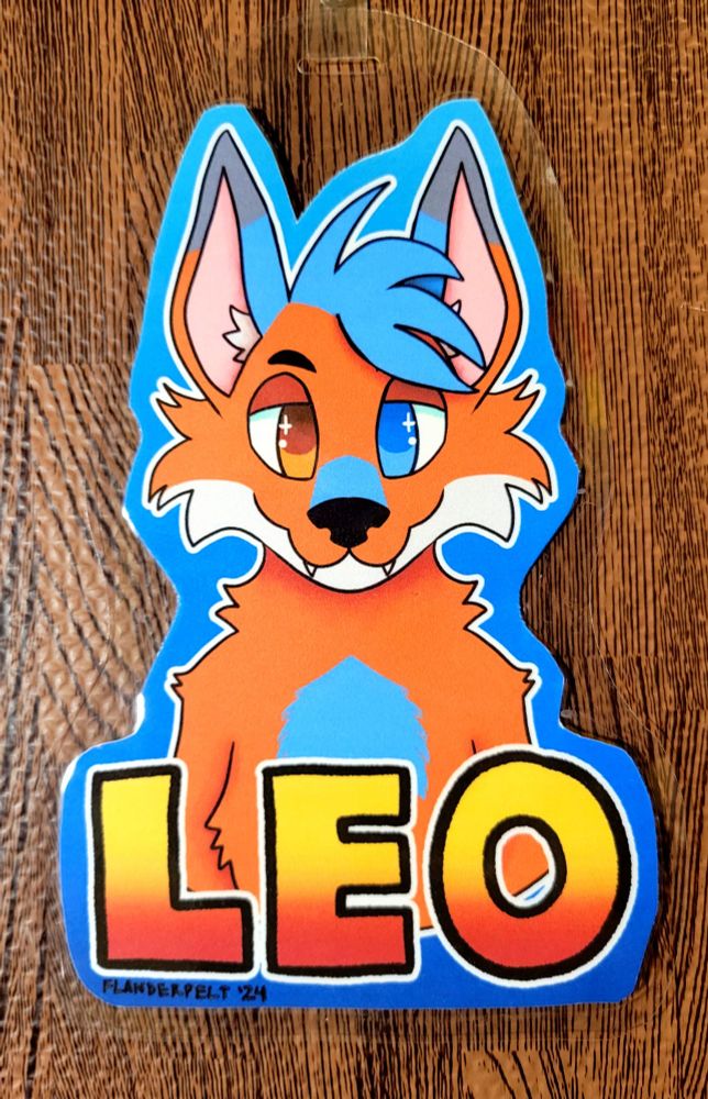 Symmetrical badge of Leo, an orange fox with blue accents, gray-tipped ears, and orange/blue heterochromatic eyes