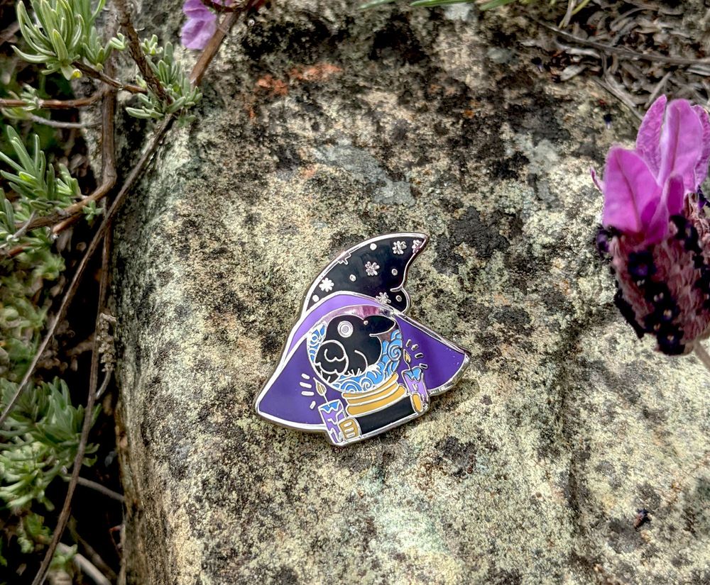an enamel pin of a crow inside of a witches hat and a crystal ball as a familiar - silver plating metal. 