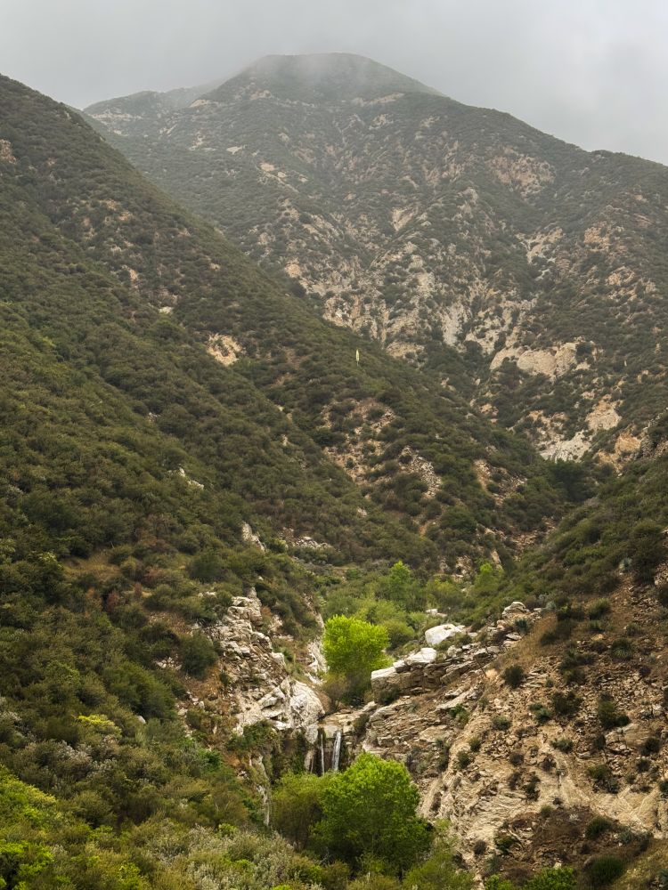 View of a waterfall surrounded by misty mountains