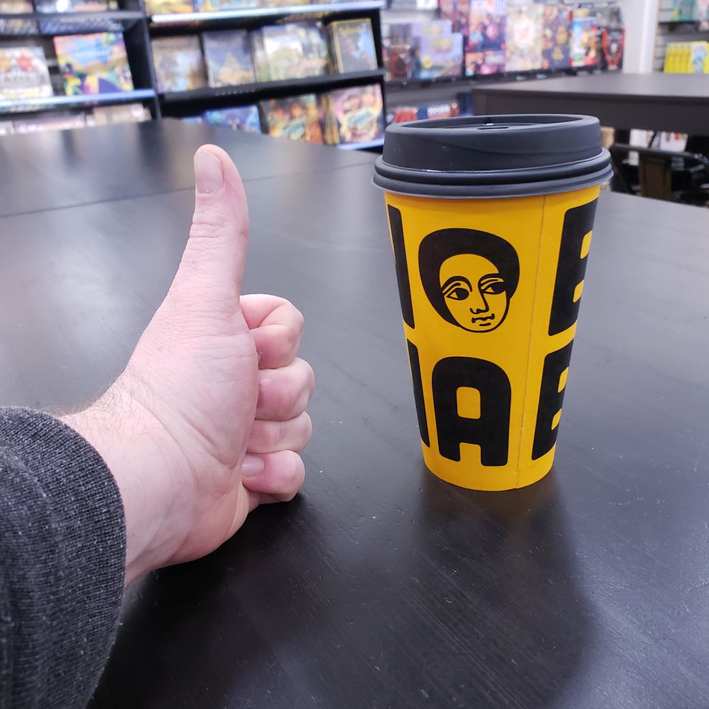 POV thumbs up next to a black and yellow coffee cup from Seattle roaster Boon Boona. 