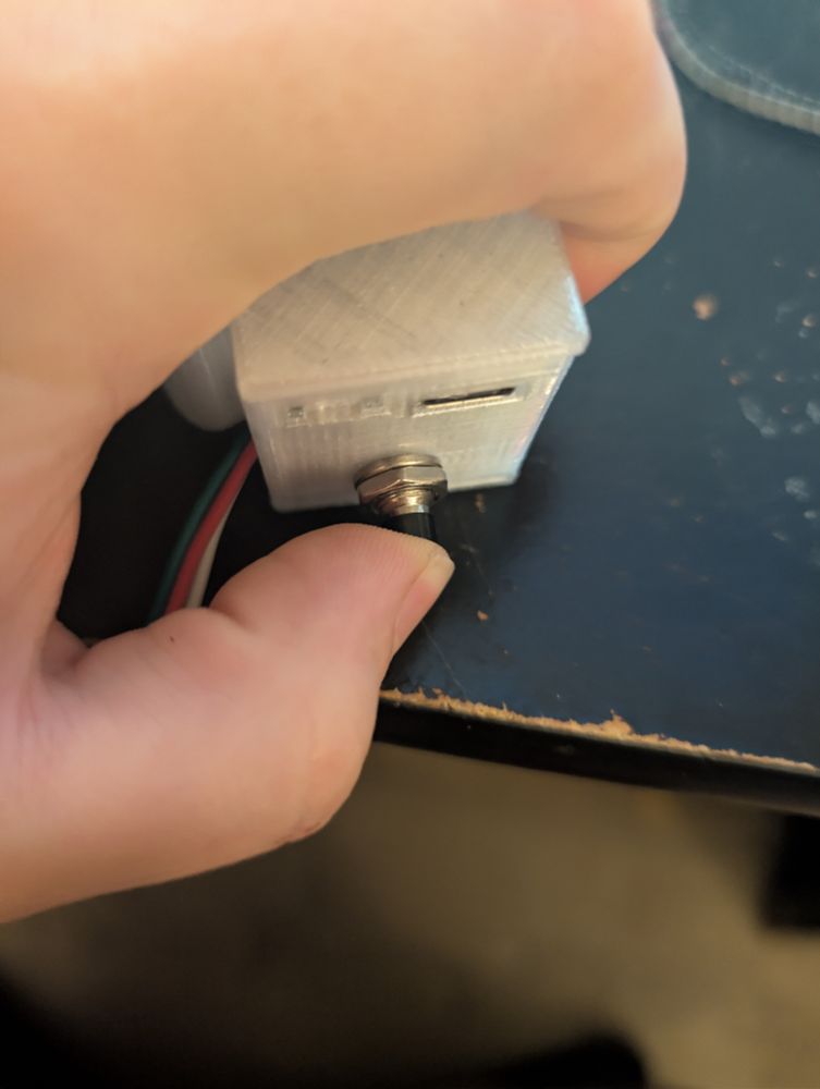 Controller close up of push button being held. 
6mm switch buttons used. 
Thumb for scale. 
