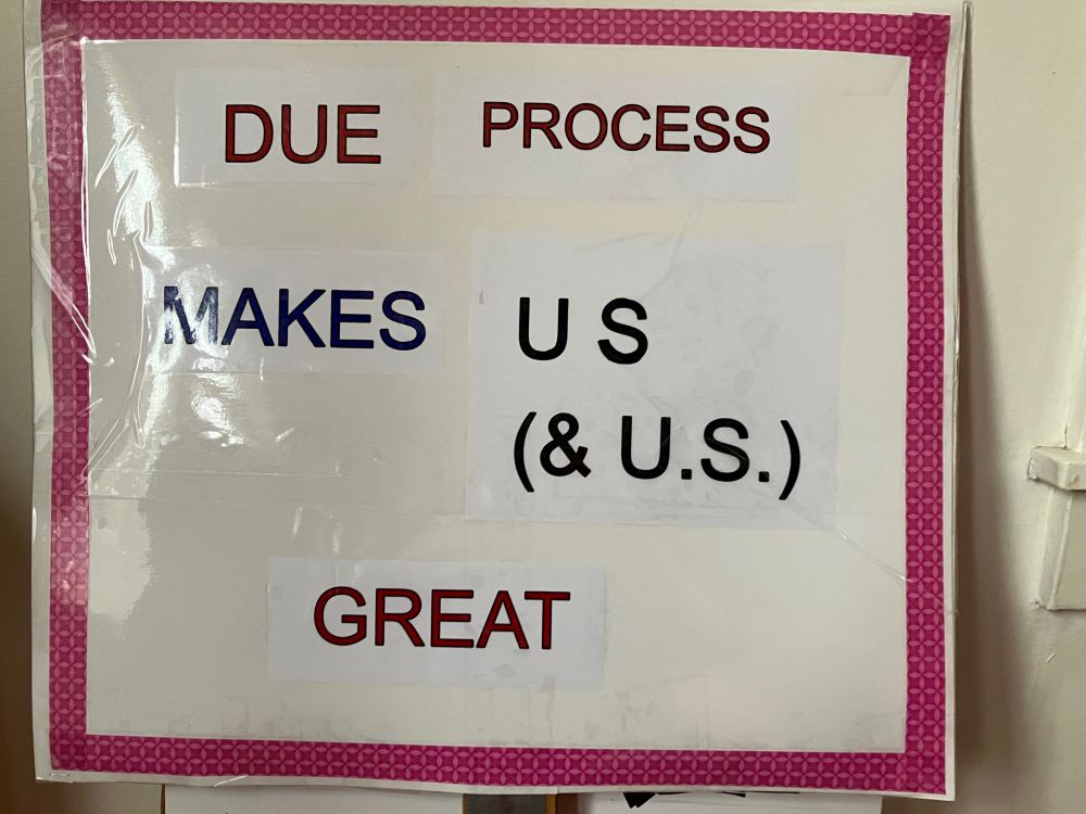 Sign that says “DUE PROCESS MAKES US (& U.S.) GREAT. Pink tape on border. 