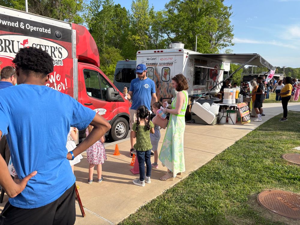 Students and families gather at food trucks during ArtsFest.  