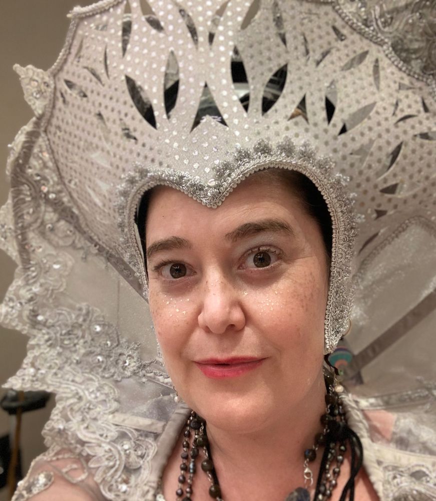 Picture of C. S. E. Cooney, a woman in a fancy silver space empress headdress and silver double lace collar in the renaissance style. 