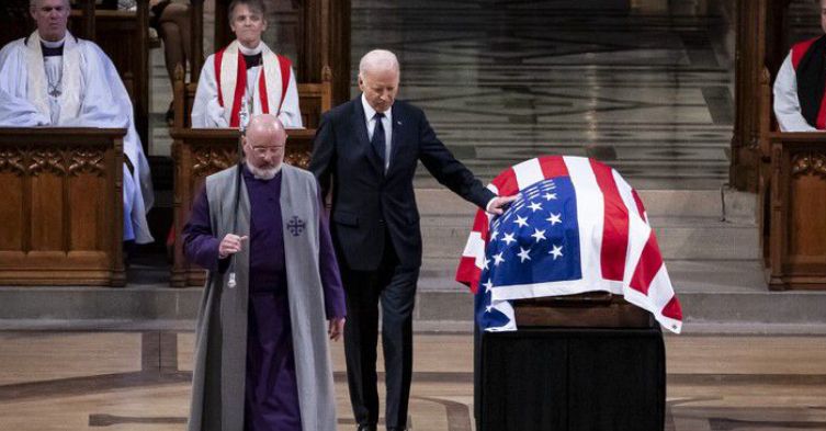 President Biden resting his hand on the late President Carter's flag-covered coffin.