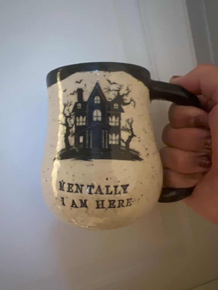 Coffee mug with a haunted house, “Mentally I am here.”