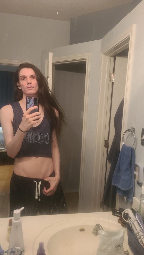Tall and thin fem twink wearing black shorts and dark grey crop top. 