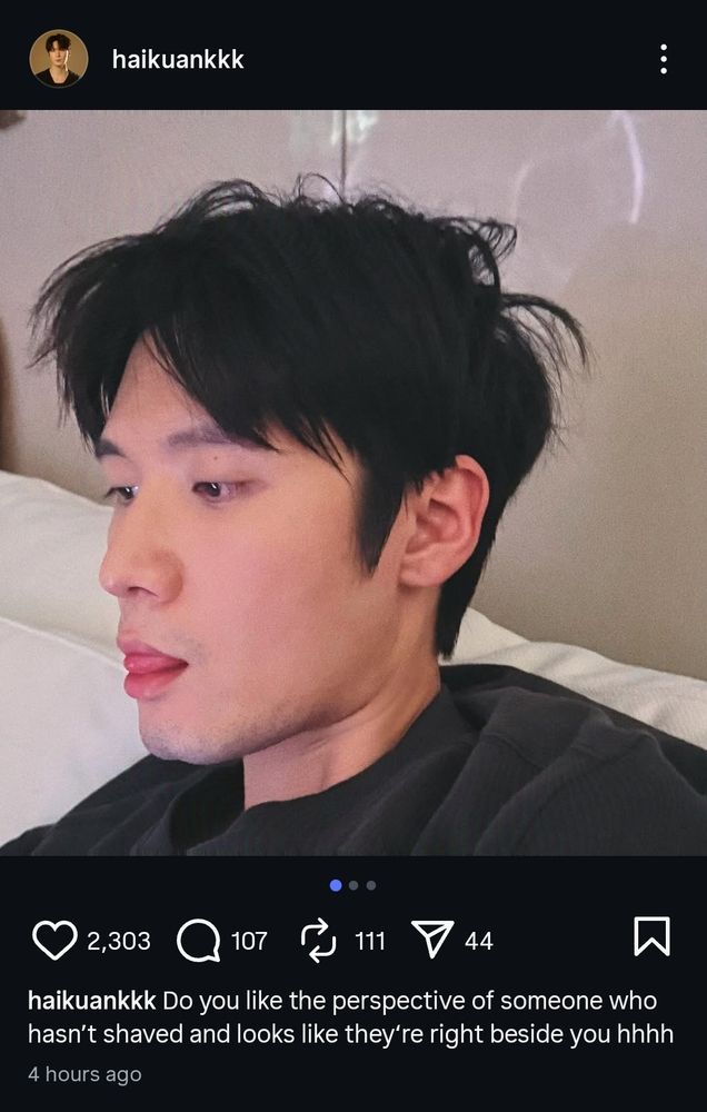 Screenshot of LHK's Instagram with a photo of him with slightly mussed hair, unshaven, and his tongue sticking out in a blep. He's presumably sitting on a white sofa and he's wearing a black sweater. Caption reads: "Do you like the perspective of someone who hasn't shaved and looks like they're right beside you hhhh"