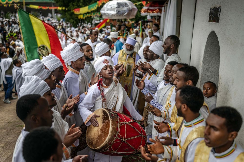 Ethiopian Orthodox deacons and a priest sing religious songs, play drums, and hold flags during a New Year church celebration at Entoto St. Raguel Church in Addis Ababa, on September 11, 2025. Ethiopia marks the New Year, Enkutatash in Amharic, on September 11, celebrating the end of the rainy season and the start of the Ethiopian calendar year 2018, which runs about seven to eight years behind the Gregorian calendar. (Photo by Luis TATO / AFP)