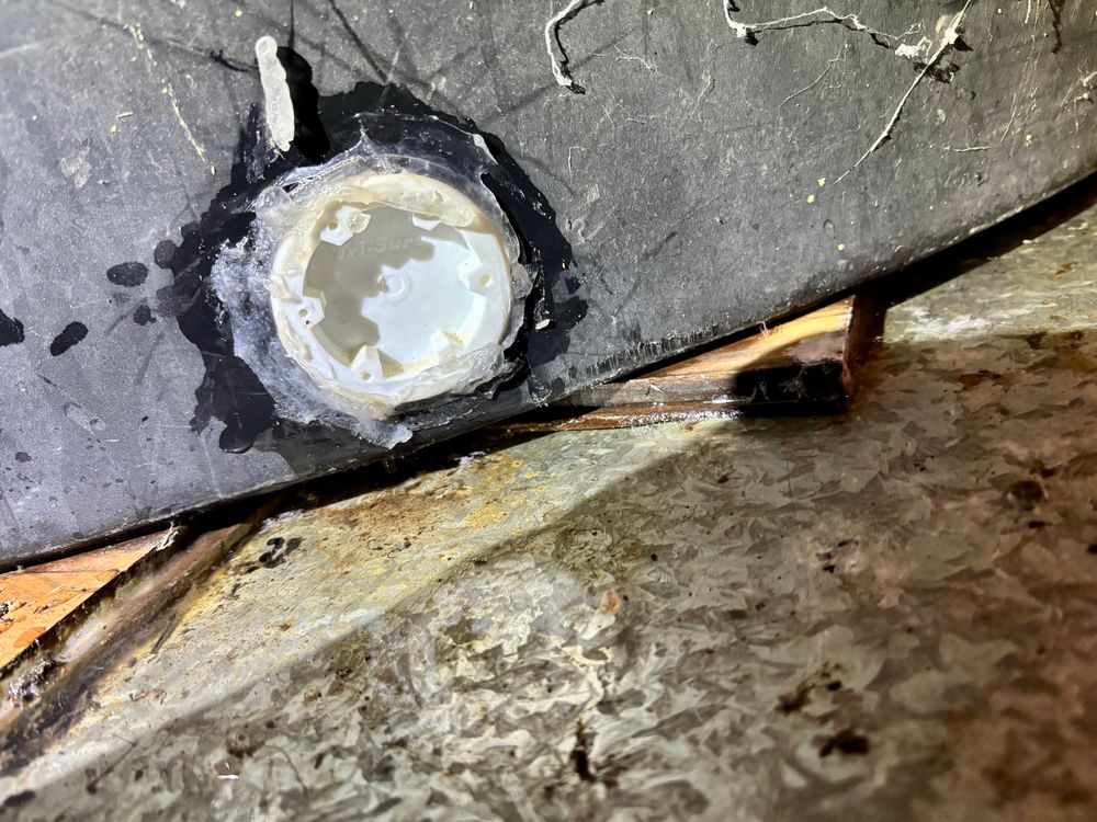 Detail of buttress plug in the side of said trough, surrounded by clear silicon. Trough sits atop a big galvanised metal tray installed by past Dave on the off chance the trough ever leaked.