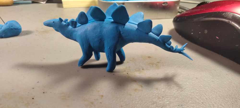 A side three quarters pose with the stegosaurs neck raised and tail lowered