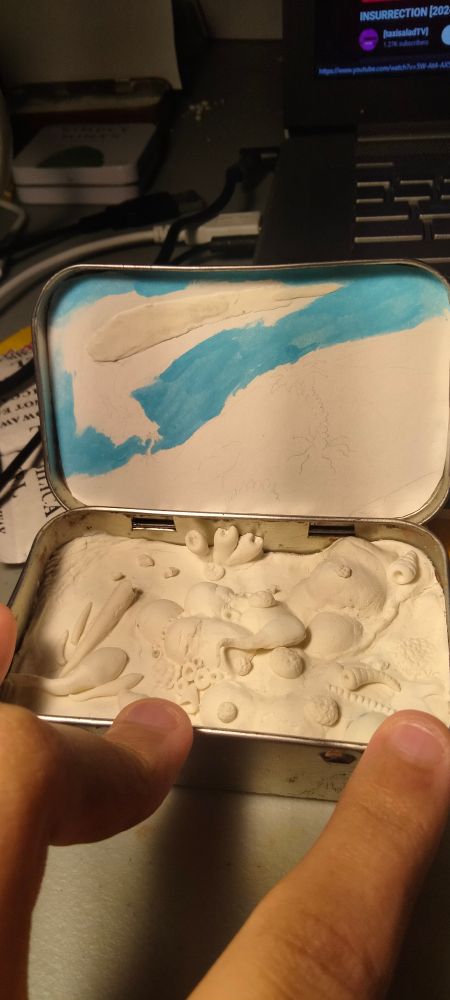 An altoid can with the inside of it filled with clay to have a sculpted diorama of an ancient ecosystem. Can you tell which time period its meant to be? 