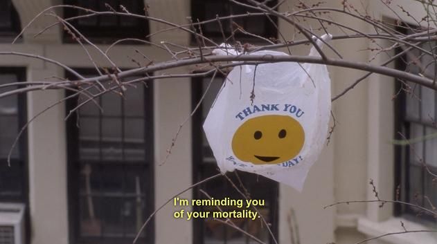 a white plastic bag in a tree with a yellow smiley face and the words i'm reminding you of your mortality at the bottom--it is a scene from 30 Rock