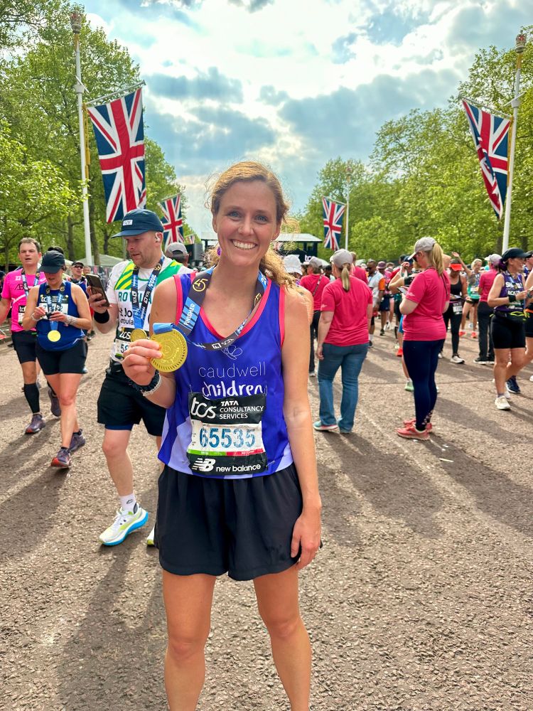 Standing at the finish line with my Caudwell Children’s singlet and medal.