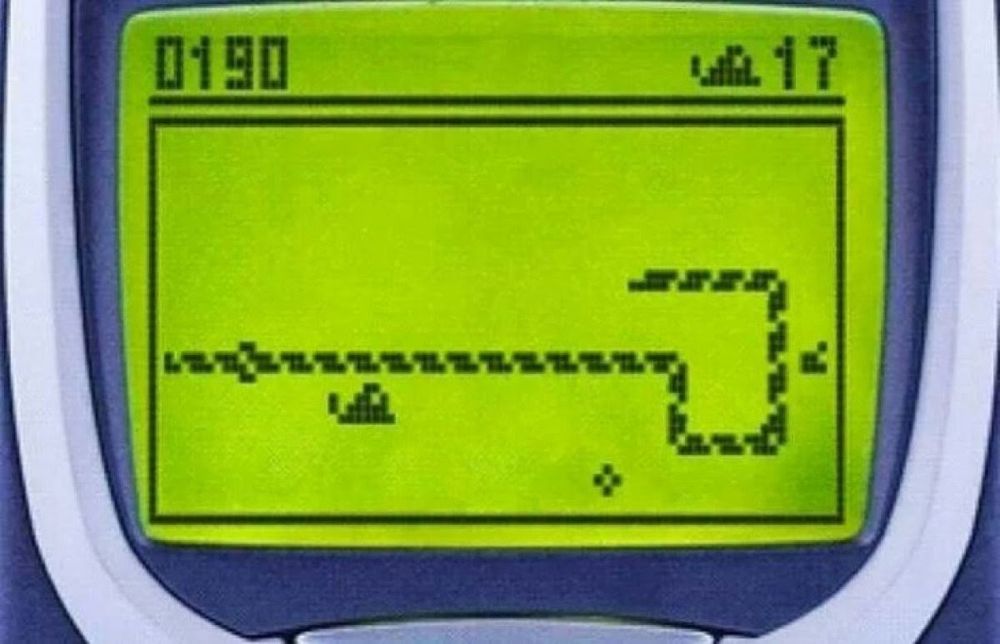 A close-up of a Nokia phone displaying a game of snake