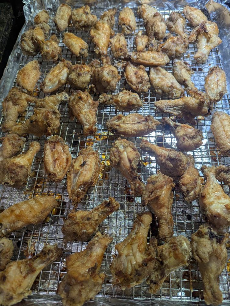 Cooked seasoned chicken wings on baking tray.