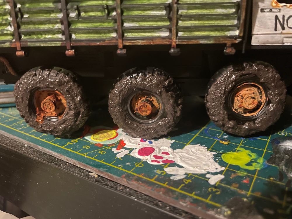 Three wheels of the Alvis stalwart, covered in mud-effect paint which has been varnished to make it look wet