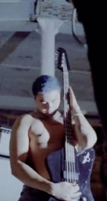 calum hood with the blue buzzcut and shirtless hugging his bass very slutty