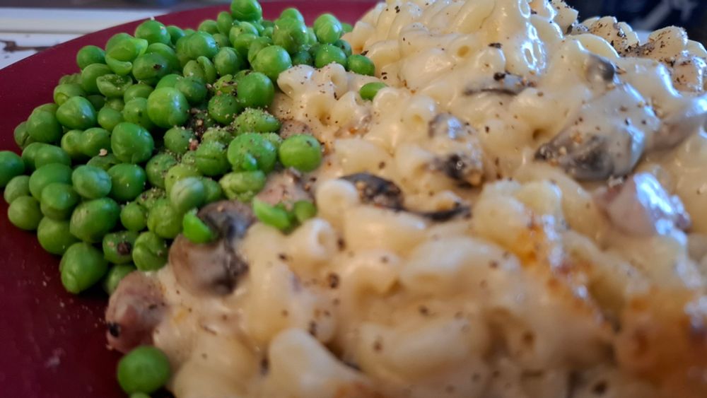 A plate of peas with homemade mac and cheese.