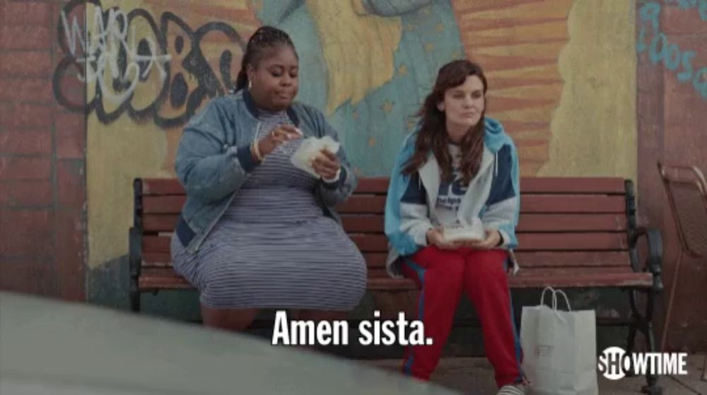 two women sitting on a bench with amen sista written on the bottom right