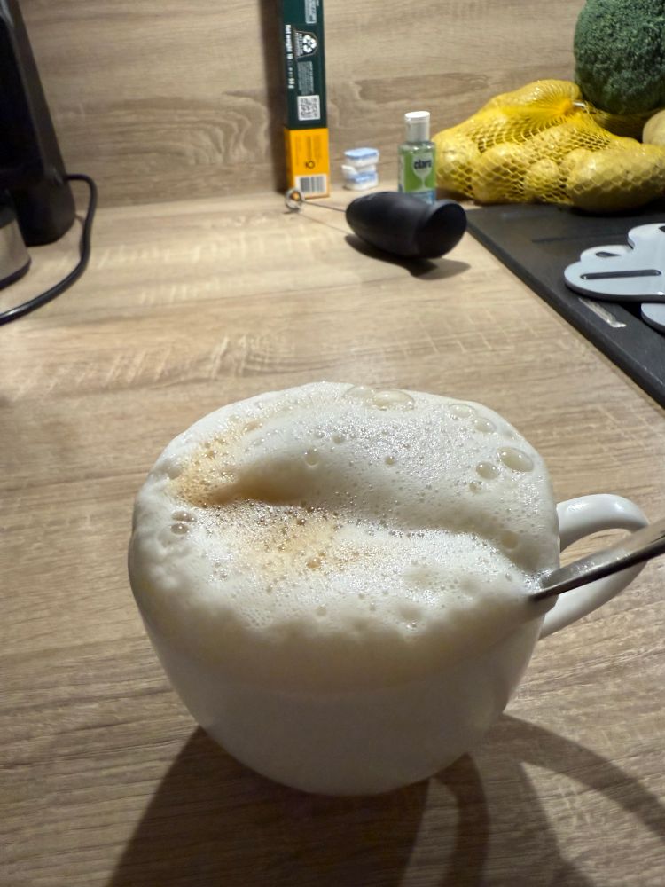 Eine Tasse Cappuccino mit sehr hoher, über den Rand hinausragenden Milchschaumkrone