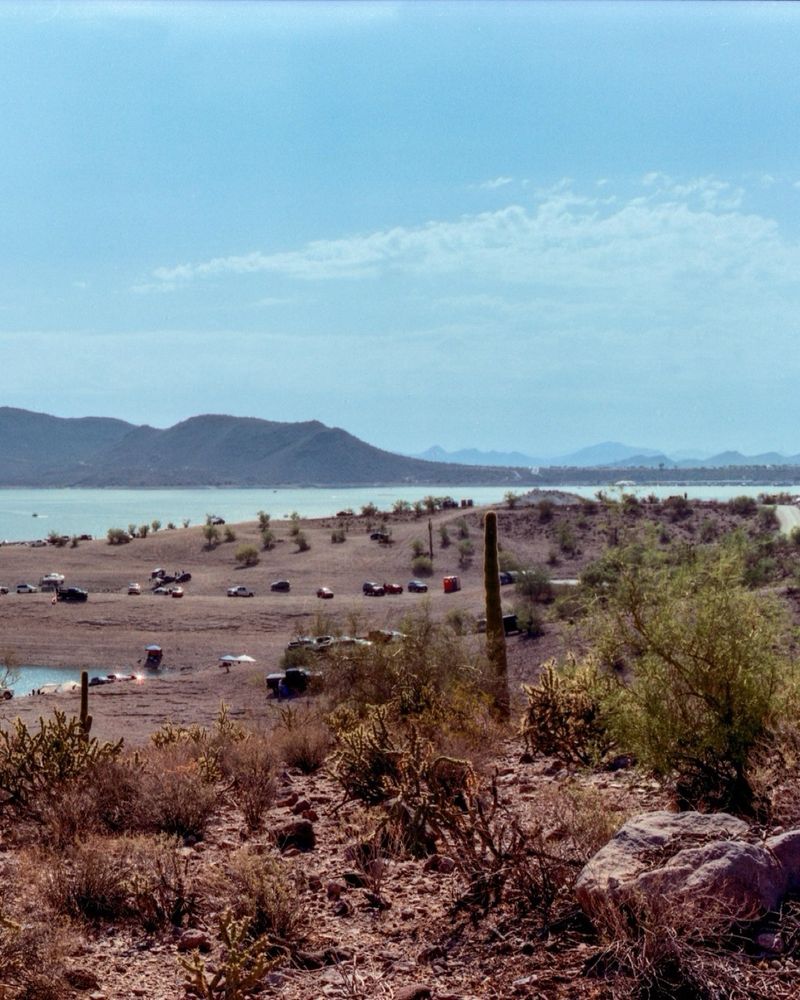 A cropped photo of the previous panoramic. In this photo, a hill full of cars is seen. Locals will park here and walk down to the lake to relax on the shore. 