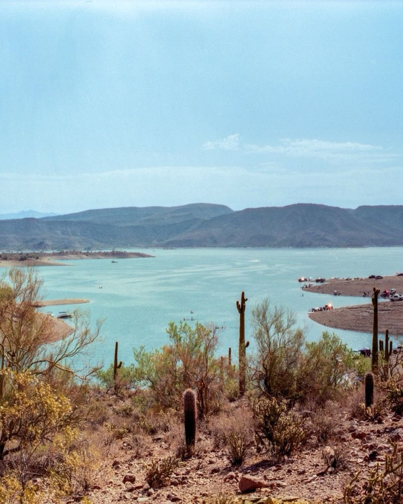 A cropped photo of the previous panoramic. In this photo, locals parked on the banks of the lake are seen as mountains rise in the background. 