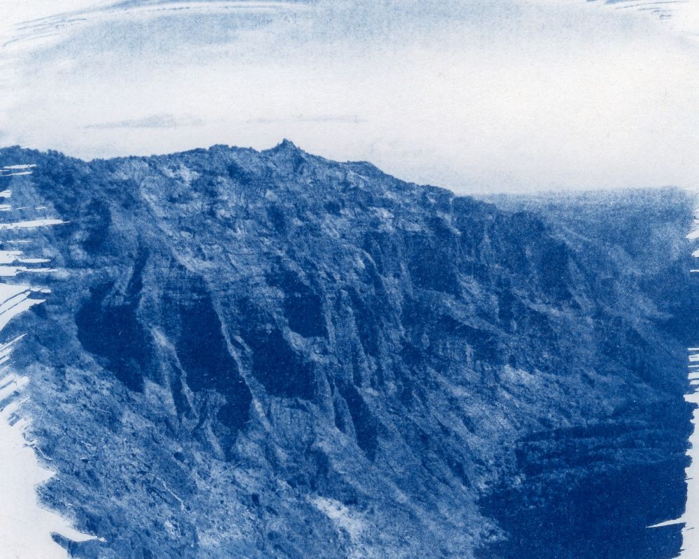 A cyanotype print of Waimea Canyon. This print was made using a transparency created from a medium format film negative. In the print, the vast canyons of Waimea are seen towering above the valley below. 
