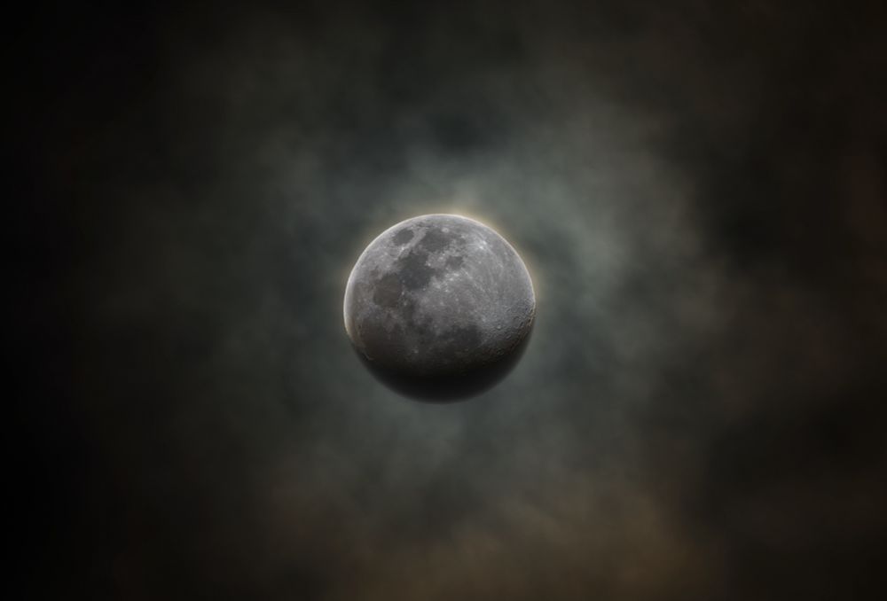 The Moon with subtle mineral colours composed on a background of dramatic glowing clouds.