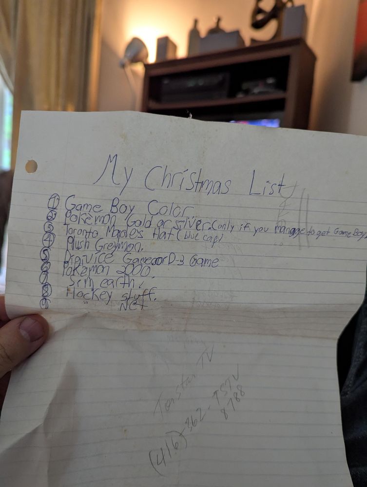 An old and child-written Christmas list on lined paper:

My Christmas List 
1) Game Boy Color 
2) Pokémon Gold or Silver (if you manage to get Game Boy)
3) Toronto Maples Hat (blue cap)
4) Plush Greymon 
5) Digivice or D3 game(?)
6) Pokémon 2000 
7) Sim Earth 
8) hockey stuff 
9) hockey net