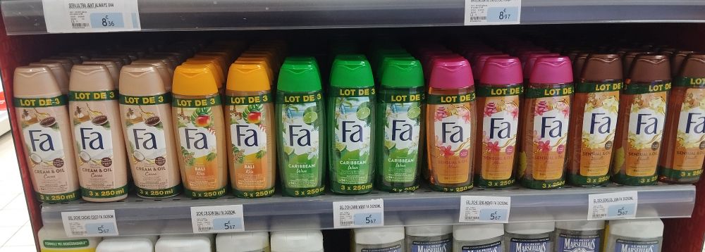 A series of shower gel bottles on a shelf which each say "Fa" on the front for some reason
