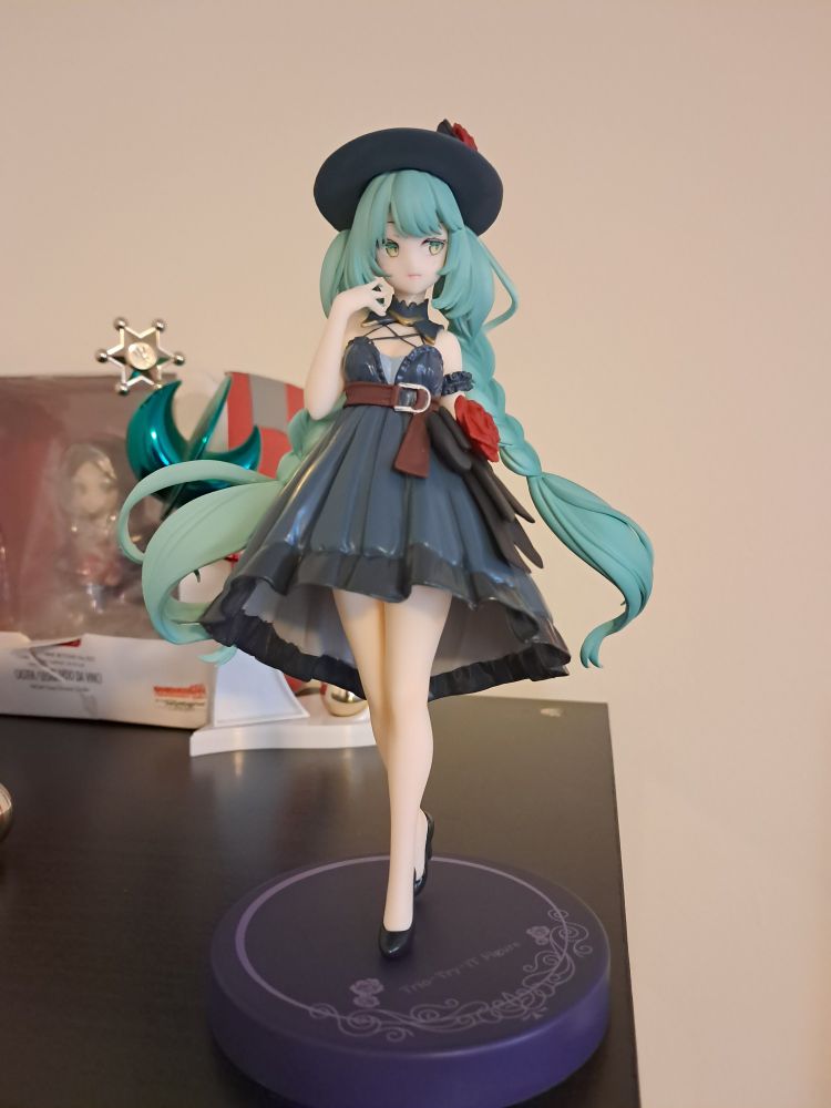 A Hatsune Miku figure in a formal dark blue dress with matching hat.