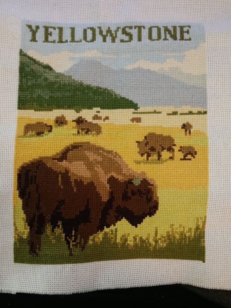 Cross stitch of Yellowstone mountains and a field grazing Buffalo 