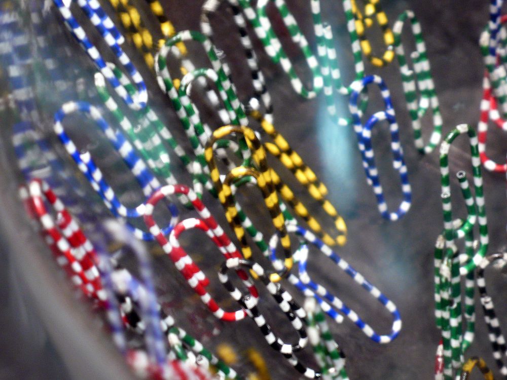 Magnetische Büroklammern in blau, grün, gelb, schwarz und rot weiß gestreift.