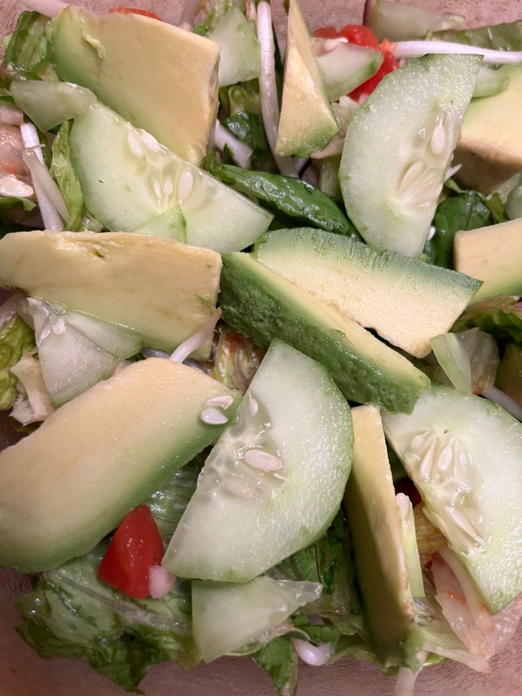 Beautiful safe salad with avocado, tomato, cucumber, carrots, purple cabbage, arugula, and romaine lettuce 