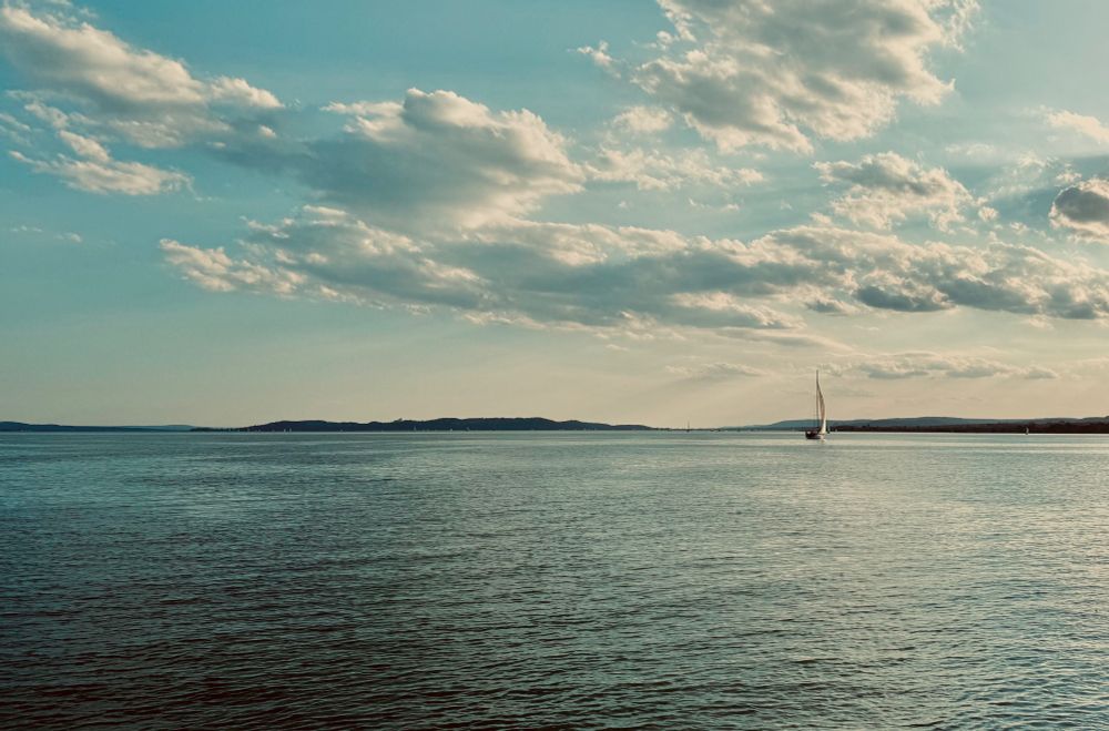 A sailboat searches for wind on the lake alone